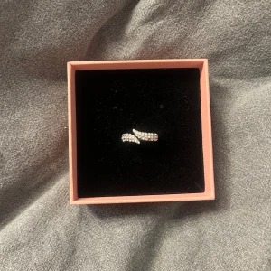 Silver ring - Silver ring med glitter stenar köpt på Åhléns men tyvärr minns jag inte hur mycket den kosta! 18mm, har tappat en glittersten som jag visar på bild 2 men syns inte när man har på sig ringen💕
