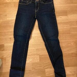 Levi's 711 Skinny Jeans W24 L30 - Snygga Levi's 711 skinny jeans i mörkblå denim. Passformen är skinny och de är tillverkade i ett stretchigt material för extra komfort. 