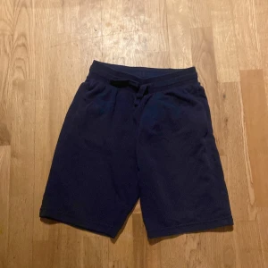 Mörkblå shorts från H&M - Säljer ett par mörkblå shorts från H&M. De har en bekväm passform med snörning i midjan för justerbarhet. Perfekta för en avslappnad stil.