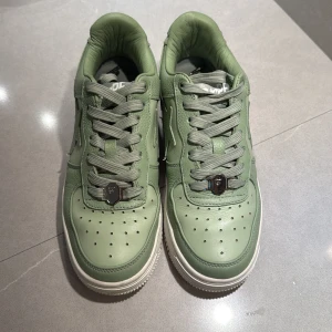 Gröna sneakers från BAPE STA - Snygga gröna sneakers från BAPE STA med klassisk stjärndetalj på sidan. Skorna har snörning och en vit sula som ger en fräsch kontrast. (Köpta i Japan) 