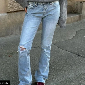 Ljusblå jeans från True Religion - Snygga ljusblå jeans från True Religion med slitna detaljer och klassisk femficksdesign. Jeansen är lågmidjade och bootcut, vilket är både snyggt och trendigt. Perfekta för en casual stil.