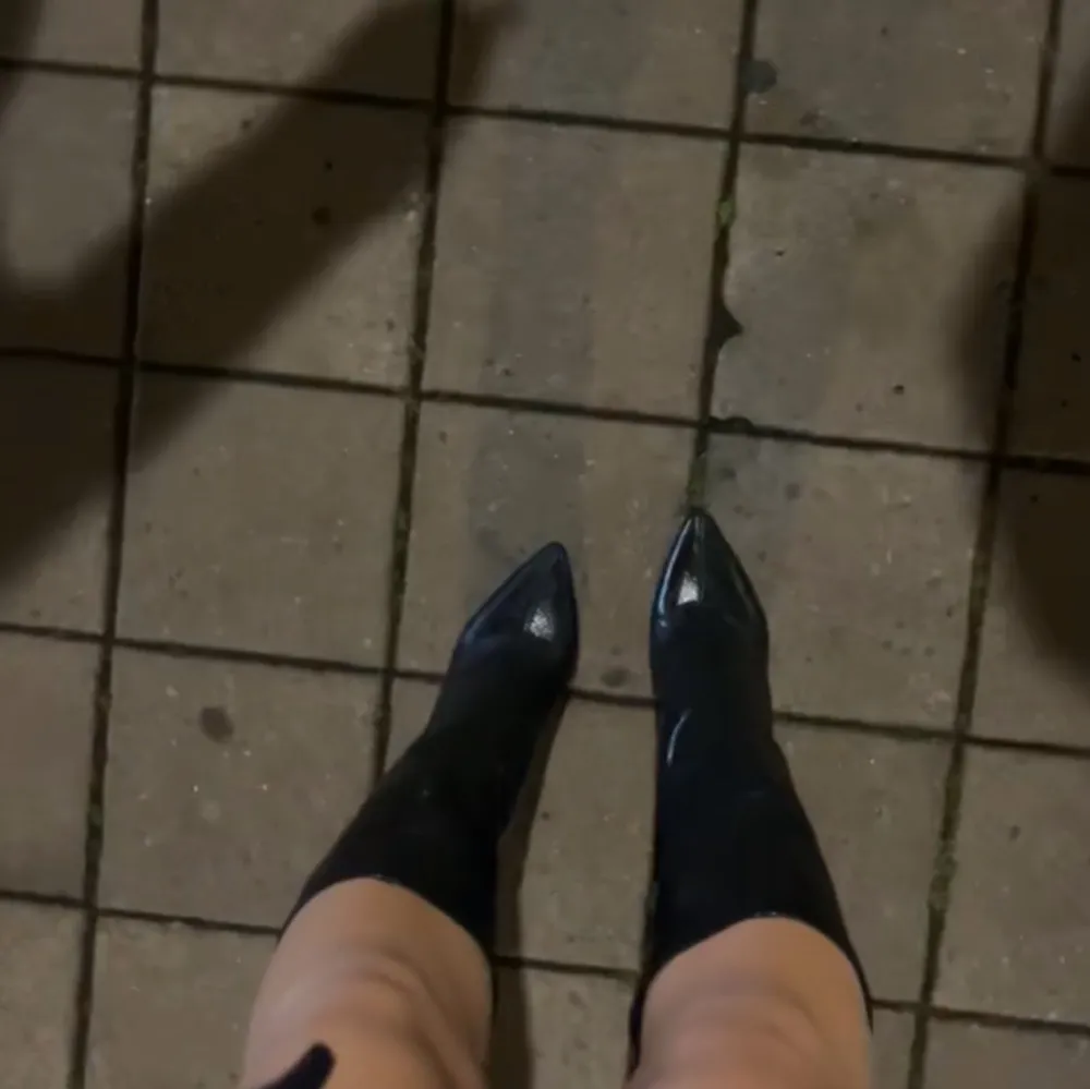 Snygga svarta boots i skinn med spetsig tå. Perfekta för en stilren look. Dem är ca 10cm höga med en tjockare klack, super snygga med orm mönster i svart skinn!. Kengät.