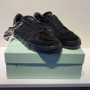 Svarta sneakers från Off-White - Snygga svarta sneakers från Off-White med klassisk snörning och Off-White-logga på sidan. Skorna har en robust sula och är tillverkade i mocka. Perfekta för en stilren look. Kvitto och box ingår💸