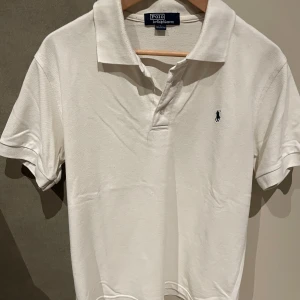 Vit pikétröja från Ralph Lauren - Säljer en klassisk vit pikétröja från Ralph Lauren i storlek L. 