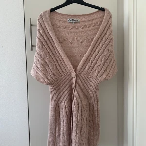 Rosa stickad kofta från Clockhouse - Säljer en mysig Rosa stickad kofta med flätstickat mönster och stora knappar framtill. Koftan har en v-ringad design och korta ärmar, perfekt för lager-på-lager-stil. Passar både till jeans och klänning. Hör av dig vid intresse! 🤎