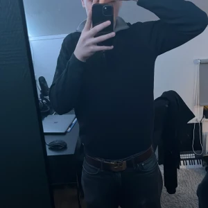 Svart tröja från Hugo Boss - Säljer en stilren svart tröja från Hugo Boss med dragkedja vid halsen och en kontrasterande grå insida på kragen. 8/10 skick har ett ihopsytt hål på ryggen och ett litet hål på framsidan som nt syns väl. Kan gå ner i pris vid snabbt köp.