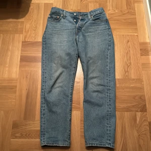 Levis 501 jeans w 25 l 26 - Klassiska Levis 501 jeans i blå denim. Dessa jeans har en rak passform och är högmidjade, vilket ger en tidlös stil. Perfekta för en avslappnad look. De har en knappgylf och fem fickor. Skick 8/10