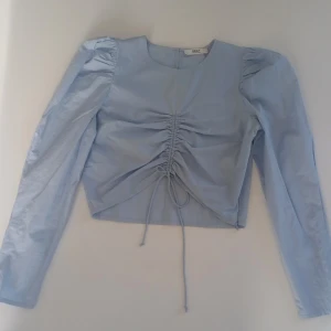 Ljusblå blus💗 - Säljer en ljusblå blus från ONLY med långa ärmar och en snygg knytning framtill. Blusen har en rund hals och en dragkedja i ryggen för enkel påklädning. Använd ett fåtal gånger och har en fin passform💗