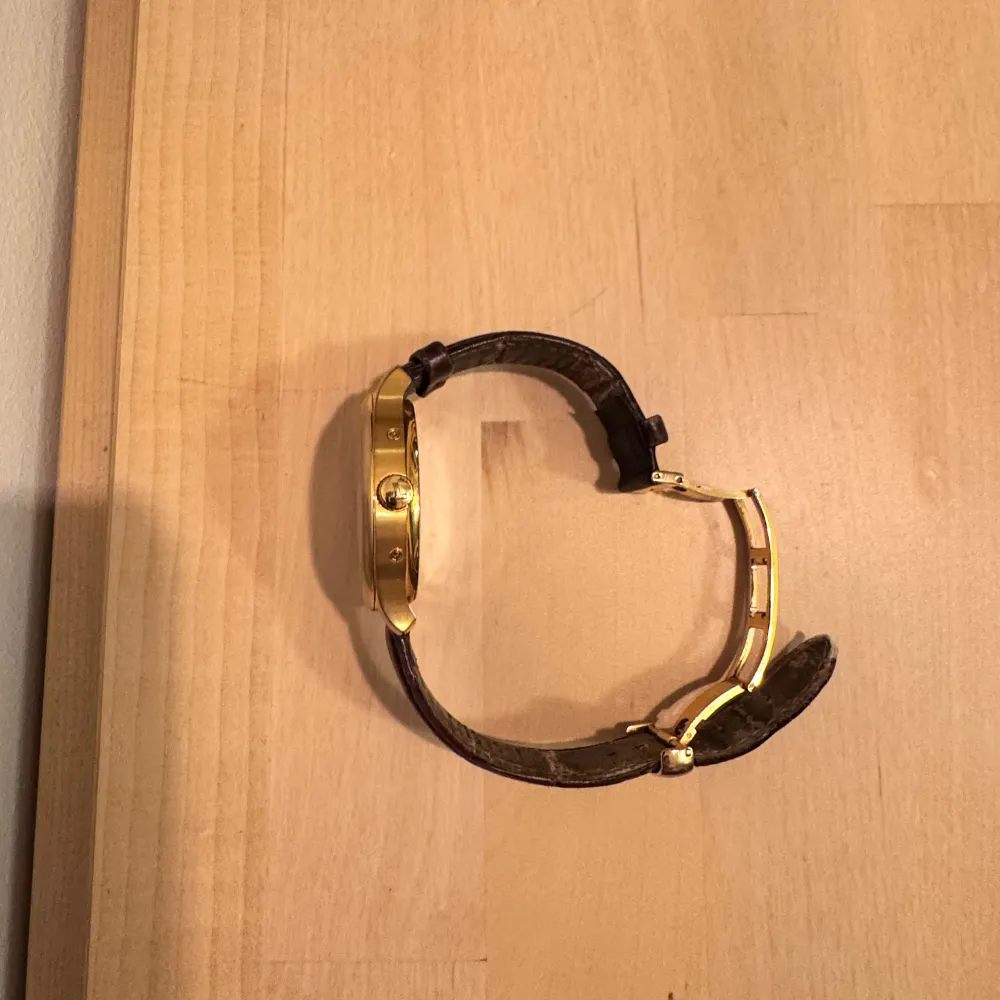 Snygg Tissot herrklocka med en stilren vit urtavla och guldtonad boett. Klockan har en brun skinnrem som ger en klassisk look. Perfekt för den som vill ha en tidlös accessoar som matchar till allt! Klockan har safirglas (kan ej repas) och 30M vattentäthet. Mindre slitage på insidan av läderbandet. Går även att lätt och billigt att byta. Kvitto finns!. Asusteet.