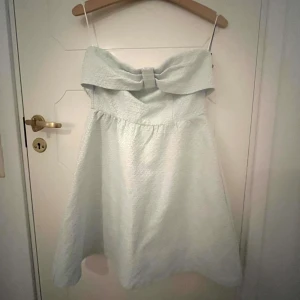 Ljusblå axelbandslös klänning med rosett - Så söt bandeauklänning med rosett, perfekt till skolavslutning eller student osv!!🤍 Den är vit med lite blått i!🙌🏼 