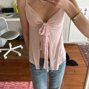 Rosa knytlinne från Gina Tricot - Säljer ett  rosa linne från Gina Tricot med knytning framtill. Linnet har smala axelband och en v-ringad design. Perfekt för varma dagar eller sommarens fester. 💖