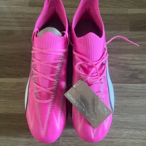 Puma fotbollsskor dam - PUMA ULTRA ULTIMATE FG/AG PHENOMENAL - POISON PINK/VIT/SVART. Aldrig använda. Kartong ingår.
