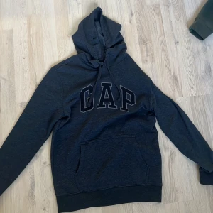 Svart GAP hoodie  - Säljer nu denna feta hoodien från Gap. Perfekt för en avslappnad look. Hoodien är knappt använd och pris går att diskuteras. Meddela vid funderingar.
