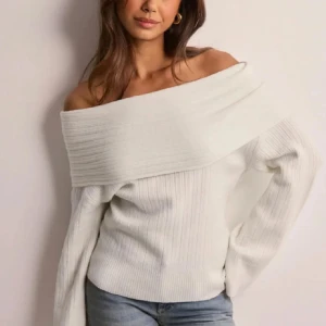 Vit offshoulder tröja - Snygg vit offshoulder tröja med ribbad design. Perfekt för en stilren look. Tröjan har långa ärmar och en bred krage som ger en elegant touch.