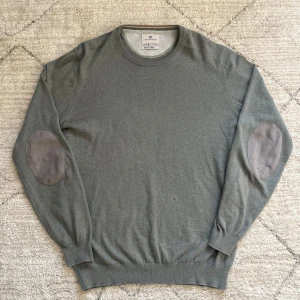 Tröja från Hansen & Jacob - Säljer en stilren tröja från Hansen & Jacob i kashmirblandning. Tröjan har långa ärmar och snygga armbågslappar i en mörkare nyans. Perfekt för en elegant och avslappnad look.