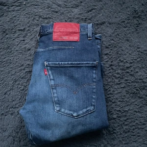 Levi's 502 jeans - Snygga Levi's 502 jeans i en klassisk blå färg. De har en straight passform och är tillverkade i slitstarkt denim. Perfekta för en avslappnad stil med fem fickor och knappgylf.