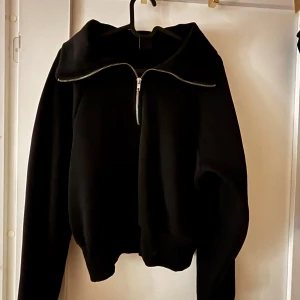 Svart zip sweatshirt - Croppad sweatshirt med halv-zip. Tröjan är i princip aldrig använd, mycket bra skick! Hör av er för fler bilder eller frågor💞