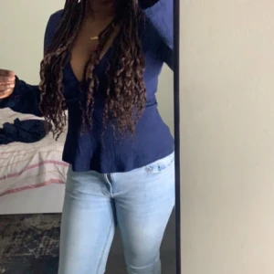 Mörkblå omlottopp - Snygg mörkblå omlottopp med långa ärmar och v-ringning. Perfekt för en stilren look. Passar bra till jeans eller kjol. Den är i ny skick köpt i gina tricot och har aldrig använd. Ny med prisplapp