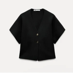 Mörkblå kortärmad tröja från Zara - Snygg mörkblå tröja från Zara med korta ärmar och v-ringning. Den har två knappar framtill och en stilren design som passar perfekt för olika tillfällen. Säljer DENNA FAST I MÖRKBLÅ!!!Nästan nyskick(endast använd 2 gånger)