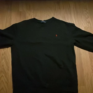 Svart tröja från Polo Ralph Lauren - Säljer en stilren svart tröja från Polo Ralph Lauren med det klassiska röda logotypbroderiet på bröstet. Tröjan har långa ärmar och en rund halsringning. Perfekt för en avslappnad och snygg look. Pris går att diskutera.
