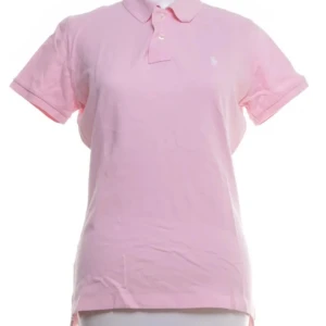 Rosa pikétröja från Ralph Lauren - Snygg ljusrosa pikétröja från Ralph Lauren med klassisk krage och knappar framtill. Tröjan är i 100% bomull och har korta ärmar. Perfekt för en fräsch och sportig look med diskret broderad logga på bröstet.