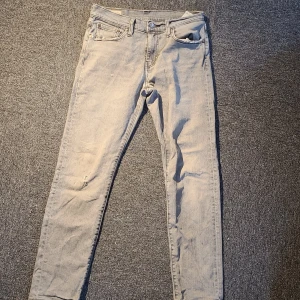 Ljusgrå Levi's 511 jeans - Säljer ett par ljusgrå Levi's 511 jeans med klassisk femficksdesign och Levi's patch bak. Jeansen har en slim passform och raka ben, tillverkade i mjukt jeanstyg. Perfekta för dig som gillar en stilren och avslappnad look.