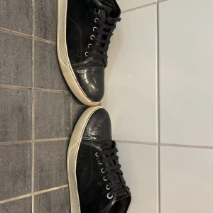 Svarta sneakers från Lanvin - Snygga svarta sneakers från Lanvin med vit sula och svarta skosnören. Kom priv för fler bilder samt frågor! Kan gå ner i pris vid snabb affär
