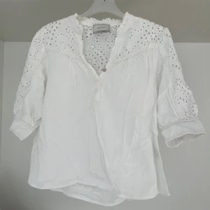 Kortärmad topp med spetsdetaljer - En mycket söt sommartopp från märket Neo Noir. Använd endast ett par gånger, så skicket är mycket bra.