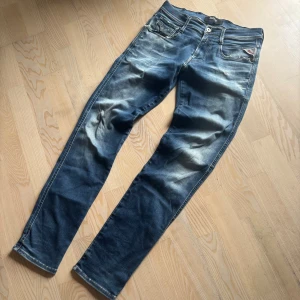 REPLAY ANBASS MED SLITNINGAR - Ett par galeettttt feta Replay jeans i den populära modellen ”anbass” med sjuka slitningar. Nypris på dessa jeans ligger upp mot 2000kr. Storlek är 29/32 och passar tts! Priset är ej hugget i sten!