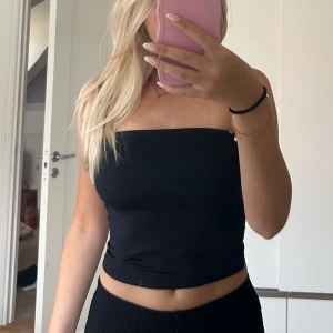 Svart tubtopp - Säljer en enkel och stilren svart tubtopp. Perfekt att matcha med både jeans och kjol. Toppen är croppad och sitter tight runt kroppen. Aldirg använd (lappen sitter kvar) Från bershka. Storlek S