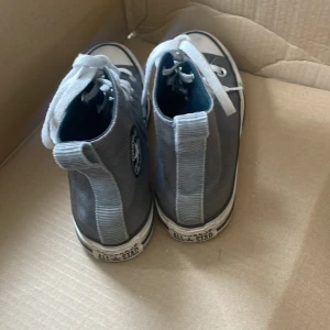 Grå Converse All Star high-tops - Klassiska Converse All Star high-tops i grått tyg med vita snören. Lite använda och i väldigt bra skick.  Pris kan sänkas vid snabb affär. 