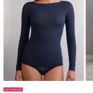 Intimissimi - En enkel och stilren mörkblå långärmad topp med rund halsringning. Tunn och stretchig i materialet, perfekt att bära som lager eller för en minimalistisk look.