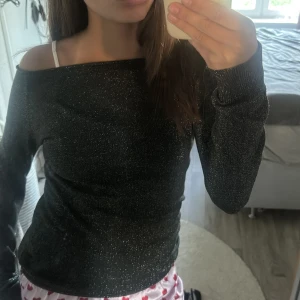 Glitter tröja - Skit snygg glitter tröja som passar till vardags och fest!☺️ Köpt på vinted. Tröjan är offshoulder och svart med silver glitter. Skulle säga att den passar XXS-S beroende på hur man vill den ska sitta🥰 Jag har Xs som referens och är 160 cm💕🫰