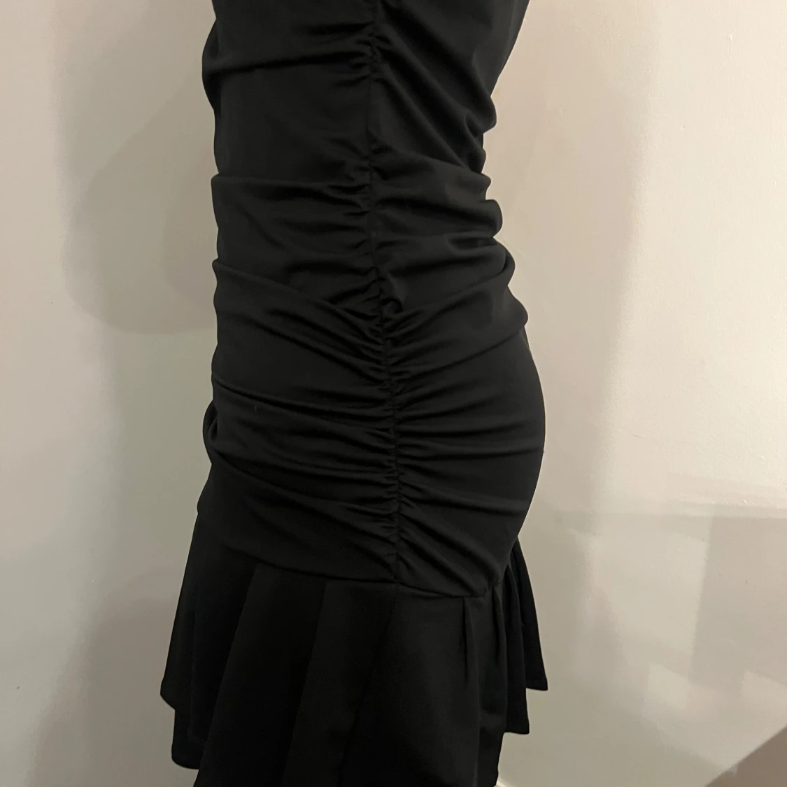 Svart tight klänning med volang