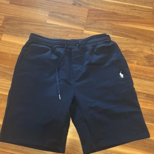 Mörkblåa Ralph lauren shorts - Säljer mina shorts som inte passade. En vän köpte dom i en outlet i Stockholm och kom hem med dom men dom passade inte så bra tyckte jag. Nu kan jag inte returnera dom så säljer dom. Helt oanvändna med etikett. Köpta för originalpris 1250kr