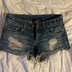 Blå jeansshorts med fransar från Tally Weijl - Säljer ett par blå jeansshorts från Tally Weijl med slitna detaljer och fransig nederkant eftersom det tyvärr är för små . Klassisk femficksmodell med låg midja och råa kanter. Perfekta för varma dagar och en avslappnad stil 💗