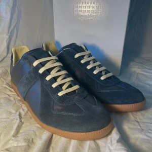 Maison Margiela skor marinblå - Ett par marinblåa Maison Margiela skor. Storlek 42 men passar även 43. Helt oanvända och i strålande skick. Dustbags ingår. Priset är inte hugget i sten!