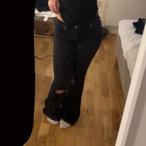 Svarta bootcut jeans med slitningar - Säljer ett par svarta bootcut jeans från Salt. De har hål på knäna. De är mellan midjade. Storlek Xs.