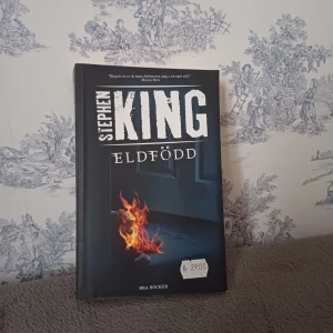 Eldfödd - Säljer boken 'Eldfödd' av Stephen King, utgiven av Bra Böcker. En spännande berättelse med ett omslag som visar en eld i ett mörkt rum. Perfekt för dig som älskar skräck och thrillers. Boken har ett efterord av John-Henri Holmberg.