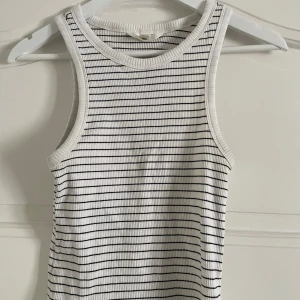 Randig ribbad topp - Säljer en stilren vit och svart randig ribbad topp. 