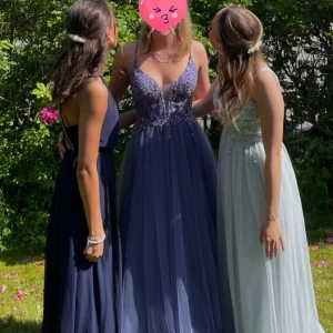 Långklänning i lila med paljetter - Säljer en fantastisk långklänning i lila med glittrande paljetter och smala axelband. Klänningen har en vacker snörning i ryggen och en elegant v-ringad design. Perfekt för balen! Nypris var 4000 kr och den är köpt i en butik i Malmö som inte finns kvar längre. Den har några få trådar som hänger mer pärlor men det syns knappt på håll. Den har knytning i ryggen så kan justeras lite men i och med dragkedjan under snörningen så kan man inte knäppa helt om man har över storlek M ungefär.