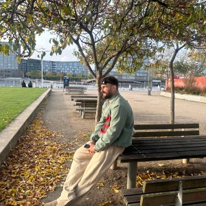 Grön jacka från Gucci - Säljer en snygg grön jacka från Gucci med röda och gröna detaljer. Jackan har en dragkedja framtill och långa ärmar. Perfekt för att ge din outfit en lyxig touch.