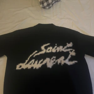 Saint Laurent knit sweater - Den trendiga knit sweatern från Saint lauren. Perfekt för en stilren look. Tröjan har en klassisk passform och är tillverkad i ett mjukt material. Pris kan diskuteras vid snabb affär. Vill mest bara bli av med den😁