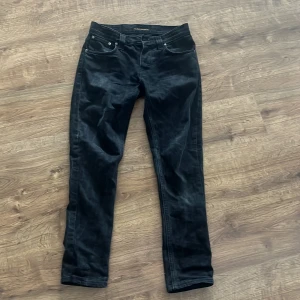 Svarta jeans från Nudie Jeans Grim Tims - Snygga svarta jeans från Nudie Jeans med en femficksdesign. De har en slimfit passform och är tillverkade i ett slitstarkt material. Perfekta för en stilren look. 9/10 skick, sunt använda och inga slitage!