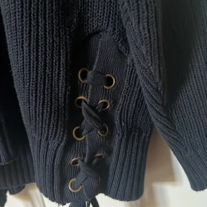 Svart stickad tröja med snörning - Säljer en jättesnygg mörkblå stickad tröja med knyt på sidan.💙