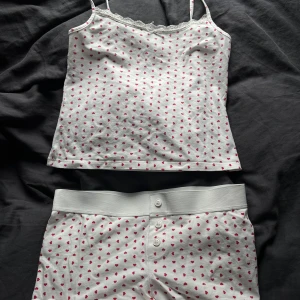 Pyjamas med hjärtmönster - Söt pyjamas med röda hjärtan och spetsdetaljer vid halsen. Nästan aldrig använd💕den är köpt på gina young och är i storlek 158/164 men passar mig som vanligtvis har xs😊
