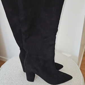 Svarta stövlar med klack - Snygga svarta stövlar i mocka med spetsig tå och klack. Perfekta för en stilren look. Mycket fint skick endast provade!