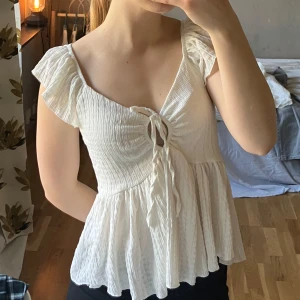 Vit blus från 157 - Säljer en söt vit blus från lager 157 med volangärmar och knytning framtill. Super bekväm och i storlek S. Använd Max 2 gånger 