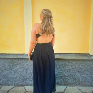 Svart långklänning med öppen rygg - Säljer min balklänning jag hade 2023, toppenskick från Nelly. 