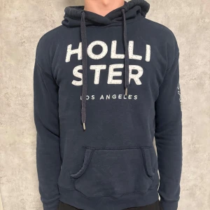 Mörkblå hoodie Hollister - En snygg mörk blå hollister hoodie som passar till allting. Hör av er vid minsta fundering!